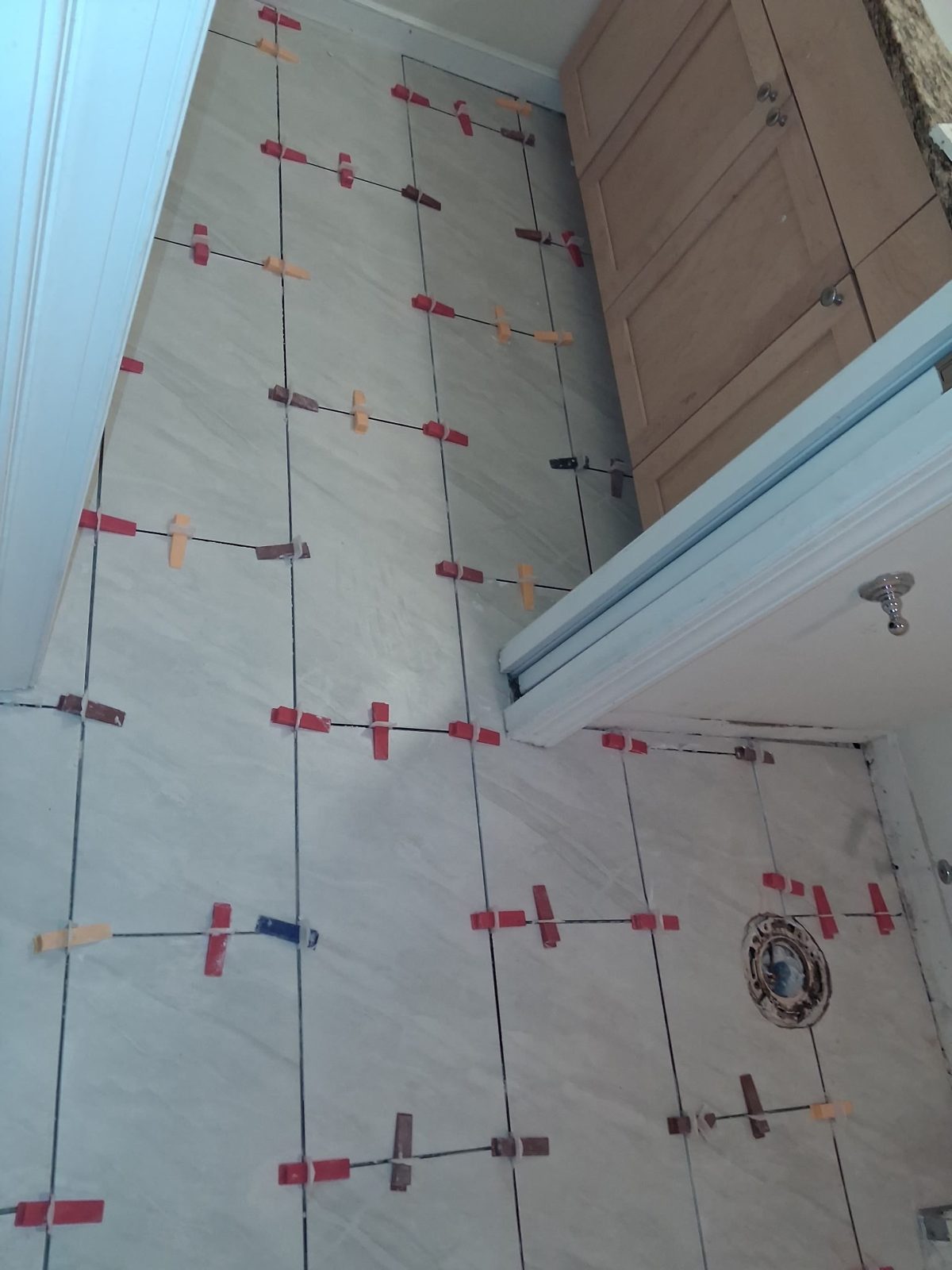 Large-format floor tile laid out with spacers before grouting